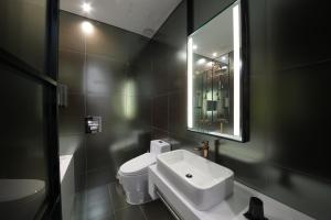 a bathroom with a sink and a toilet and a mirror at Cullinan Gaepo in Seoul