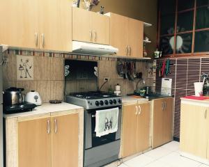 a kitchen with a stove and wooden cabinets at Blacky Hostel and Apartments in Cusco
