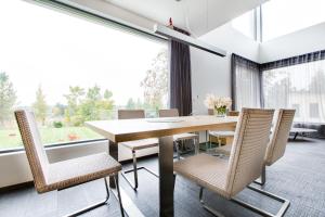 a dining room with a table and chairs and a large window at Sun Villa in Imatra +47 photos