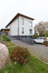 a white house with a car parked in front of it at Sun Villa in Imatra