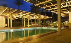 a swimming pool under a pavilion at night at Casa Rio Resorts Athirappilly in Athirappilly