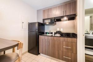a kitchen with a black refrigerator and a table at Studio 6 Extended Stay - Duluth, GA - Atlanta - Gwinnett Place in Duluth