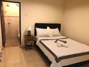 a small bedroom with a bed and a bathroom at Patra House in Ubud