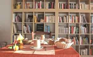 a table with a book shelf filled with books at B&B S'Ena in Suni
