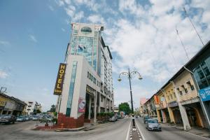 a building with a clock tower on a city street at Muarar 99 Hotel in Muar