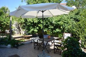una mesa con sombrilla en el patio en Vasiliki's House en Mitilene