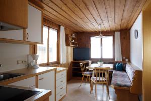 eine kleine Küche mit einem Tisch und einem Sofa in der Unterkunft Mein Elternhaus Gästehaus Waltraud Fink in Au im Bregenzerwald