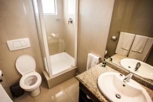 y baño con aseo, lavabo y ducha. en Coastlands Durban Self Catering Holiday Apartments en Durban