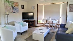 a living room with a couch and a table at Must Love Dogs B&B & Self Contained Cottage in Rutherglen