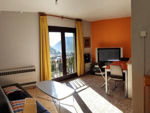 a living room with a couch and a table and a television at Apartamentos Arinsal 3000 in Arinsal