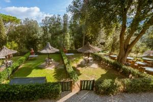 una vista aérea de un jardín con mesas y sombrillas en Il Castagno Toscana en Campiglia Marittima