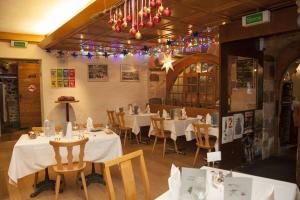 un restaurant avec des tables blanches, des chaises et des lumières dans l'établissement Hostellerie du XVI Siècle, à Nyon