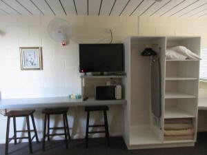 a desk with a tv and two bar stools at Waterview Motel Maclean in Maclean