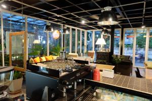 a restaurant with a bar with glass walls at B Samcook Home16 in Chiang Mai
