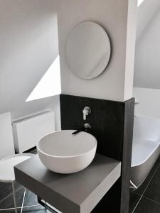 ein Badezimmer mit einem weißen Waschbecken und einem Spiegel in der Unterkunft See-Apartment Weiden in Weiden am See