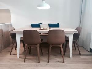 a dining room table with chairs and a white table at See-Apartment Weiden in Weiden am See