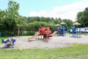 a park with a playground with a slide at Tuxbury Pond Camping Resort Tiny House Henry in South Hampton
