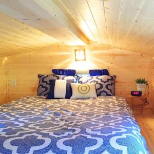 um quarto com uma cama num chalé de madeira em Leavenworth Camping Resort Tiny House Belle em Leavenworth