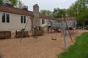 a playground in a yard next to a house at Appalachian Camping Resort Cottage 1 in Shartlesville