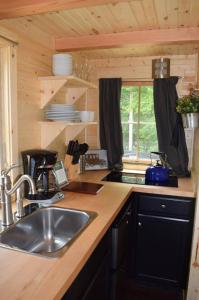 a kitchen with a sink and a counter top at Tuxbury Pond Camping Resort Tiny House Henry in South Hampton