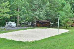 a volleyball court with a net in a yard at Sun Valley Campground Cottage 4 in Maple Grove Park