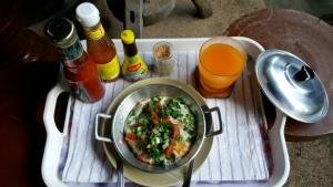 a tray with a pan of food on a table with drinks at Bansuanrachawadee B&b in Si Sa Ket