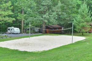 um campo de voleibol com uma rede num quintal em Sun Valley Campground Cottage 6 em Maple Grove Park