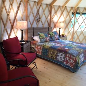 Zimmer mit einem Bett und einem Stuhl in einer Jurte in der Unterkunft Circle M Camping Resort 16 ft. Yurt 1 in Lancaster