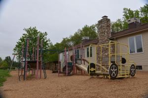 un parque infantil frente a una casa en Appalachian Camping Resort Cottage 1, en Shartlesville