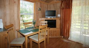 Robin Hill Camping Resort Premium Cottage 9 في Lenhartsville: غرفة طعام مع طاولة وتلفزيون