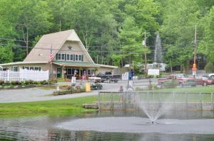 a fountain in the middle of a pond in front of a building at Sun Valley Campground Cottage 6 in Maple Grove Park