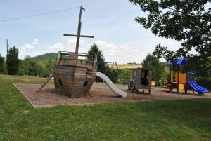 Robin Hill Camping Resort Two-Bedroom Cottage 6 في Lenhartsville: حديقة عليها ملعب مع صليب +8 صور