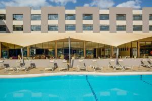 a hotel with a pool and chairs and a building at Tamarind Tree Hotel in Nairobi