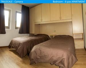 two beds in a room with cabinets at Apartment Tonale in Passo del Tonale