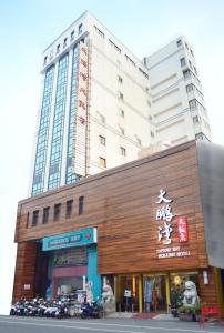 un grande edificio con moto parcheggiate di fronte di Tapeng Bay Holiday Hotel a Donggang