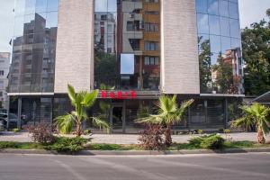 un edificio con palmeras delante en Hotel Noris en Plovdiv