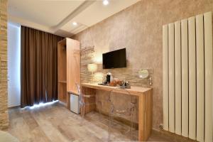 a room with a desk with a television on a wall at Veneto Suite Rome in Rome +38 photos