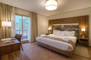 a hotel room with a large bed and a desk at Melliber Appart Hotel in Casablanca