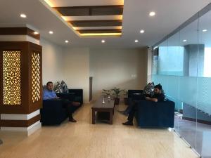 two people sitting on couches in a lobby at Kaveri Inn in Kathmandu