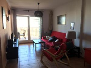 sala de estar con sofá rojo y mesa en Apartamento Mirador de Conil, en Conil de la Frontera