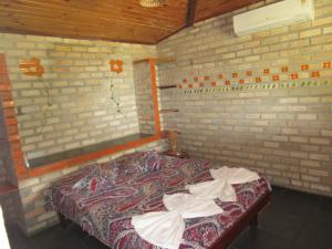 a bedroom with a bed in a brick wall at Barravilha Chales in Barra do Cunhau