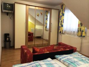 Tourist Farm Šalamun في بانوفيتشي: غرفة معيشة مع أريكة حمراء ومرآة