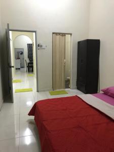 a bedroom with a bed with a red blanket on it at Cempaka Homestay Muar in Muar
