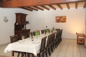 une salle à manger avec une grande table et des chaises dans l'établissement Ferienhaus am Maibüsch - rollstuhlgerecht, à Ulmen