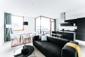 Felsen8 في هايدنهايم آن دير برينز: غرفة معيشة مع أريكة سوداء وطاولة