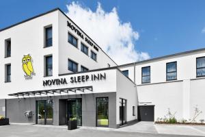 ein weißes Gebäude mit einem Schild, das Morgan sleep inn liest in der Unterkunft Novina Sleep Inn Herzogenaurach in Herzogenaurach