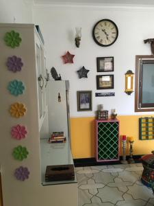 a room with a refrigerator and a clock on the wall at The Coral Court Homestay in Agra