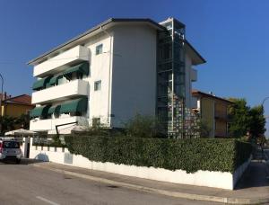 a white apartment building with a hedge in front of it at Villa Greta in Santarcangelo di Romagna