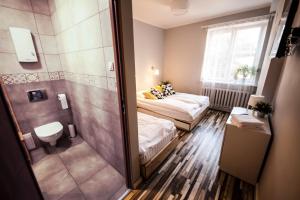 a small room with a bed and a shower at Bi-Pi Hostel in Gdańsk