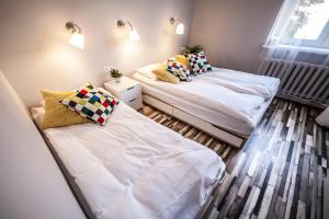 two beds in a room with white sheets and pillows at Bi-Pi Hostel in Gdańsk